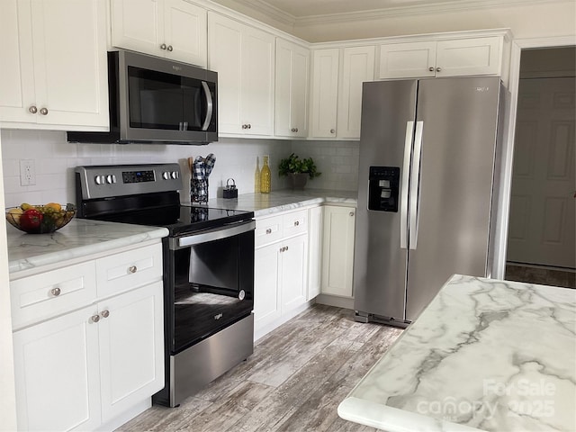 kitchen featuring white cabinets, stainless steel appliances, and light stone counters