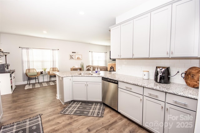 137 Tenth Green Ct, Statesville, NC 28677 - kitchen with dishwasher, a peninsula, tasteful backsplash, wood finished floors, and light stone countertops