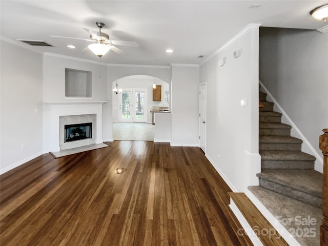 unfurnished living room with ornamental molding, ceiling fan, a fireplace, and dark hardwood / wood-style flooring