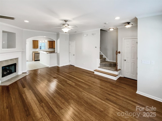 unfurnished living room with ornamental molding, a tile fireplace, and hardwood / wood-style floors