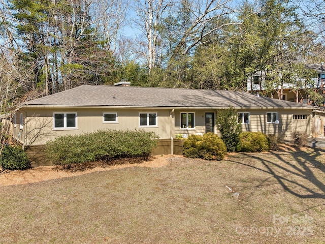 view of front of property featuring a front lawn and roof with shingles