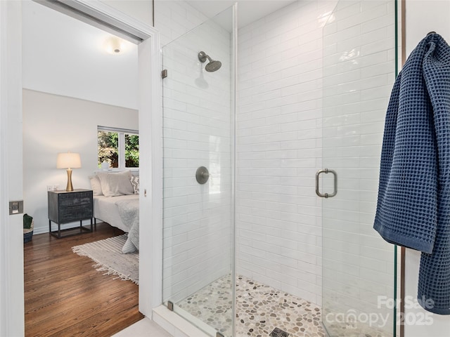 ensuite bathroom featuring wood finished floors, a stall shower, and ensuite bath