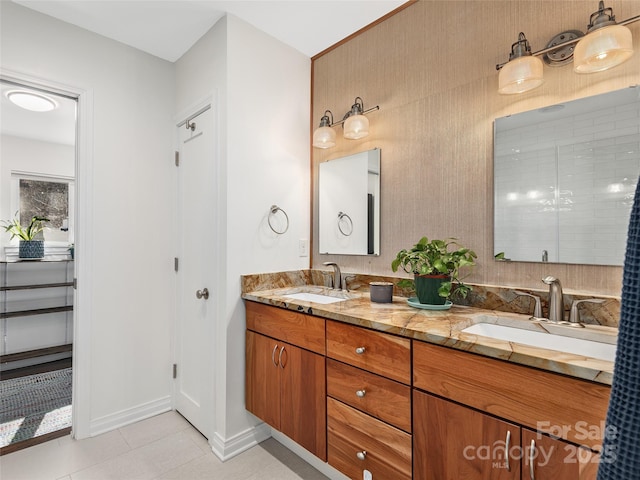 bathroom with double vanity, baseboards, a sink, and tile patterned floors