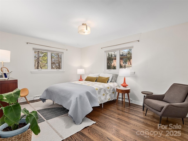 bedroom featuring multiple windows, visible vents, baseboards, and wood finished floors