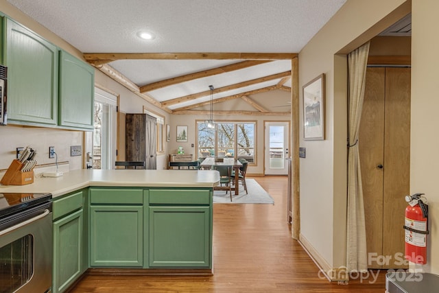 kitchen featuring stainless steel appliances, light countertops, hanging light fixtures, lofted ceiling with beams, and green cabinets