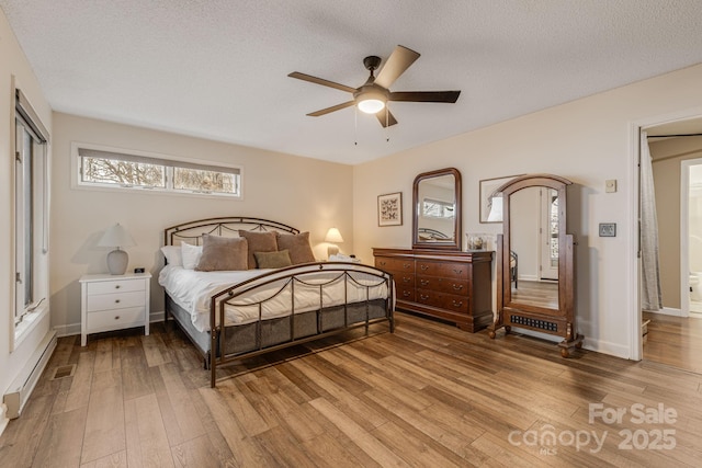 bedroom featuring a ceiling fan, light wood-type flooring, a textured ceiling, and a baseboard radiator