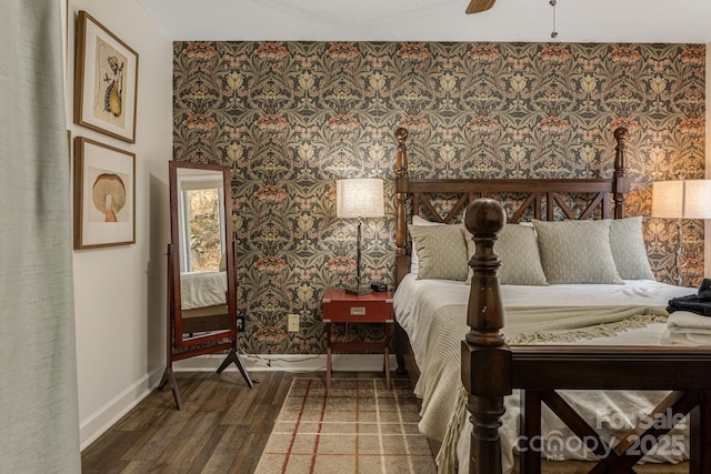 bedroom with wallpapered walls, a ceiling fan, baseboards, and dark wood-type flooring