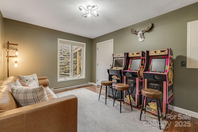 interior space featuring a textured ceiling, light wood-style floors, baseboard heating, and baseboards