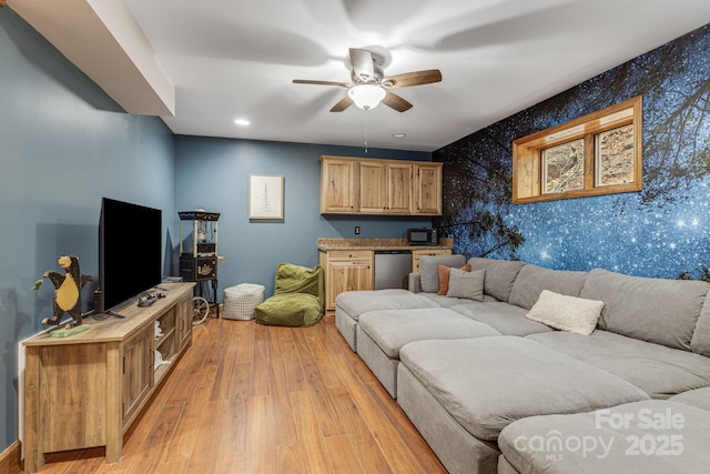 living area featuring light wood finished floors, recessed lighting, an accent wall, ceiling fan, and wallpapered walls