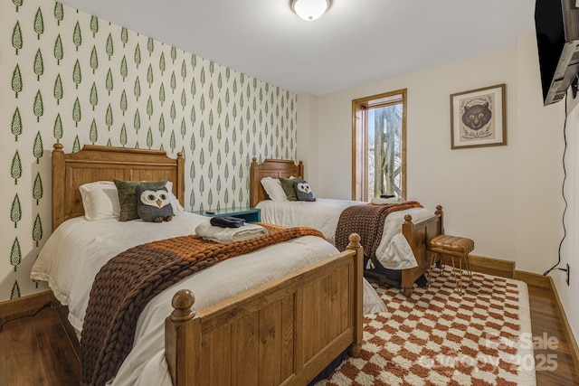 bedroom with wallpapered walls, baseboards, and wood finished floors