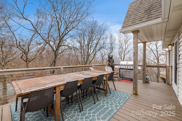 deck with outdoor dining area and area for grilling