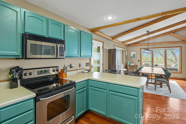 114 Spruce Hollow Rd, Beech Mountain, NC 28604 - kitchen featuring appliances with stainless steel finishes, a peninsula, light countertops, dark wood-style floors, and decorative light fixtures