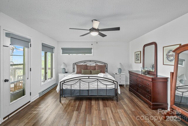 114 Spruce Hollow Rd, Beech Mountain, NC 28604 - bedroom with a baseboard radiator, wood finished floors, a textured ceiling, access to outside, and a ceiling fan