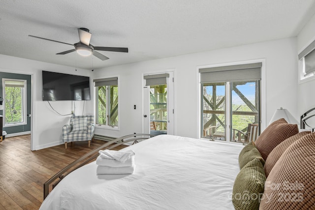 114 Spruce Hollow Rd, Beech Mountain, NC 28604 - bedroom featuring access to exterior, hardwood / wood-style flooring, multiple windows, a textured ceiling, and baseboards