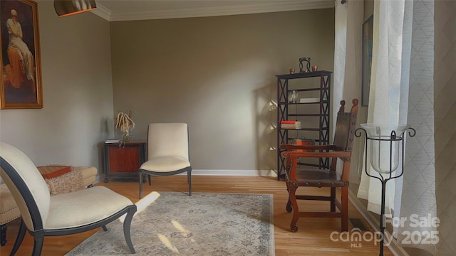 sitting room with ornamental molding and light hardwood / wood-style floors