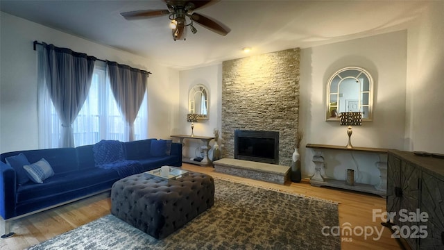 living room with hardwood / wood-style floors, a fireplace, and ceiling fan