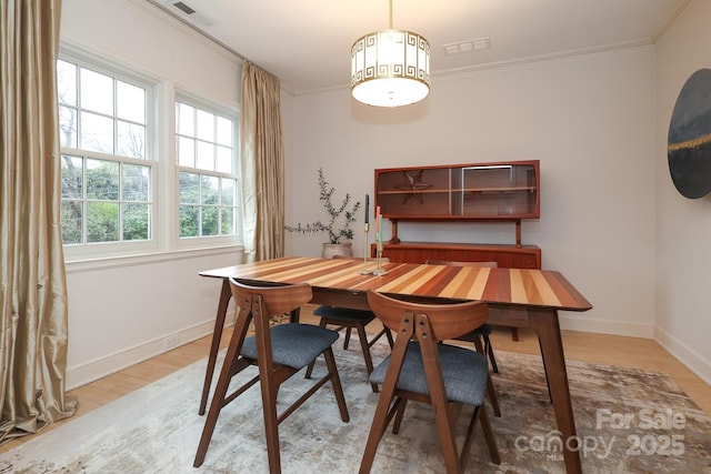 dining room featuring hardwood / wood-style floors and ornamental molding