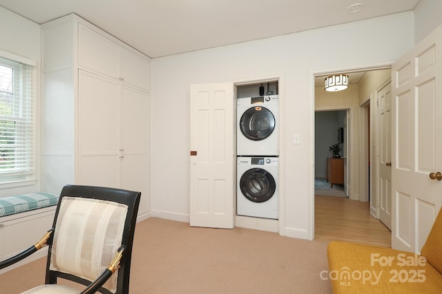 laundry area with stacked washer and dryer and light colored carpet