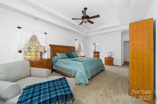 bedroom featuring a raised ceiling, ornamental molding, light carpet, and ceiling fan