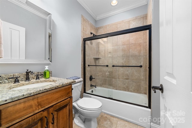 full bathroom with bath / shower combo with glass door, vanity, toilet, crown molding, and tile patterned floors