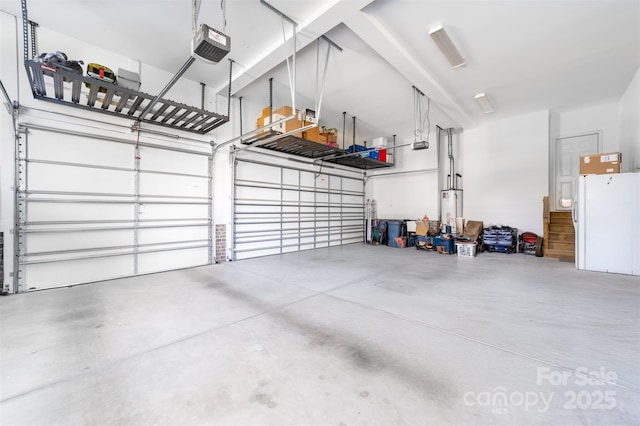 garage with a garage door opener and white fridge