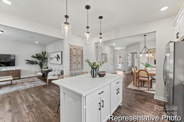 kitchen with white cabinets, stainless steel fridge, and decorative light fixtures