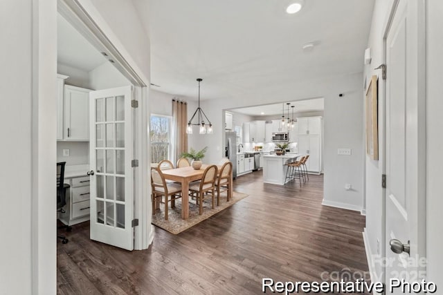 dining space with dark hardwood / wood-style floors and a chandelier