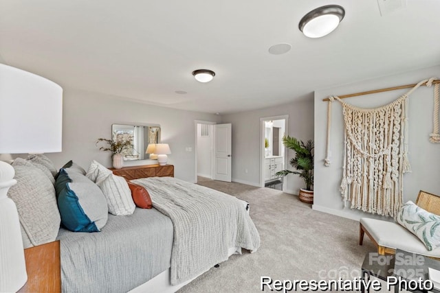 bedroom featuring ensuite bath and carpet floors