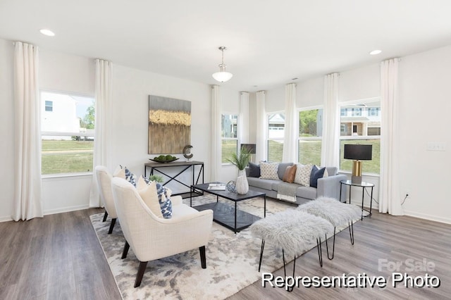 living area with recessed lighting, baseboards, and wood finished floors