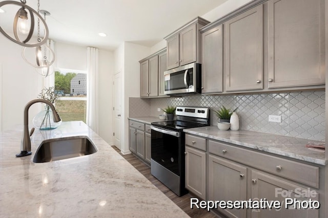 kitchen with a sink, dark wood finished floors, gray cabinetry, and stainless steel appliances