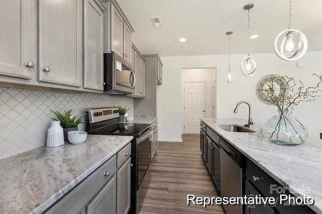 kitchen featuring a sink, gray cabinetry, backsplash, and stainless steel appliances