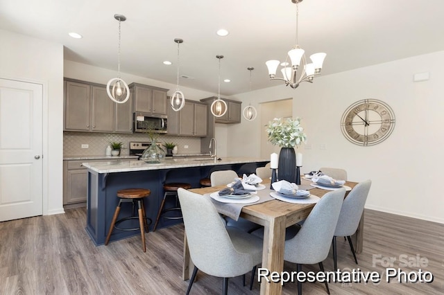 dining space with recessed lighting, wood finished floors, and a chandelier