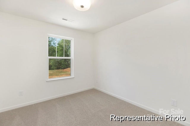 empty room featuring baseboards, light carpet, and visible vents