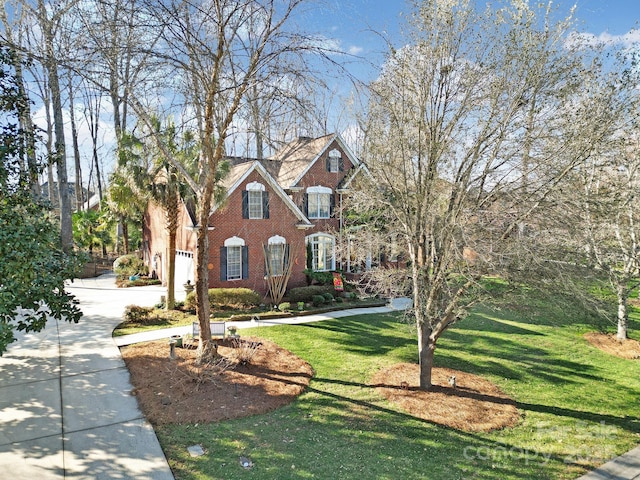 view of front of house with driveway, a front lawn, and brick siding