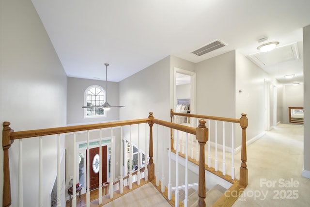 hallway featuring carpet floors, visible vents, attic access, an upstairs landing, and baseboards