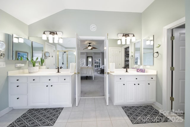 full bath featuring lofted ceiling, a stall shower, two vanities, and connected bathroom