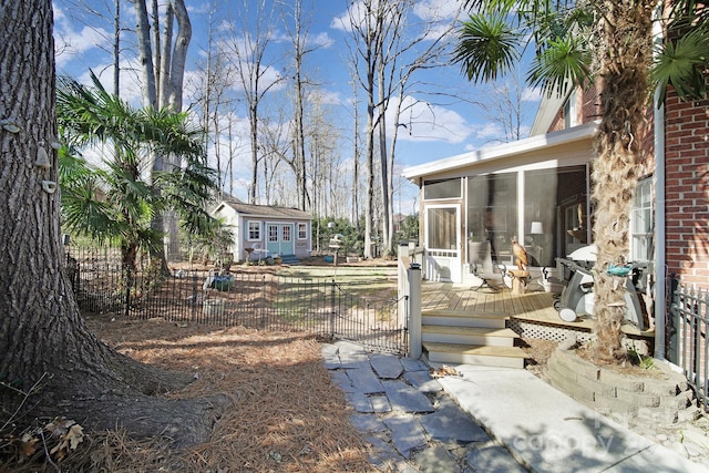 view of yard with a sunroom, fence, and a wooden deck