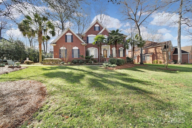 view of front of house featuring a front lawn and brick siding