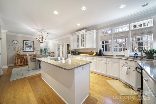 907 Thorn Ridge Ln, Lake Wylie, SC 29710 - kitchen featuring a sink, a kitchen island, black electric stovetop, white cabinets, and light wood-type flooring