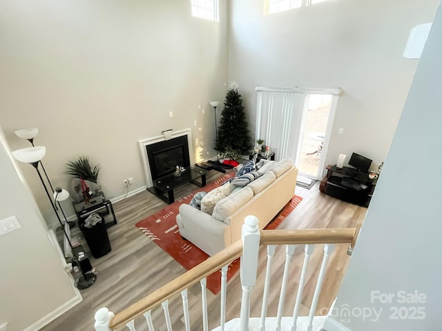 living room featuring hardwood / wood-style floors, plenty of natural light, and a high ceiling