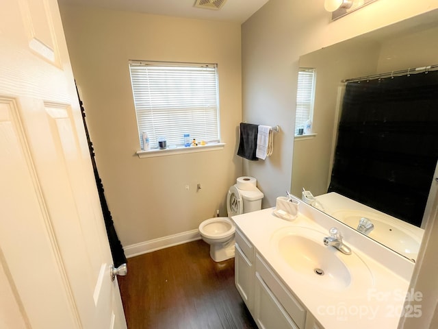 bathroom with hardwood / wood-style flooring, vanity, and toilet