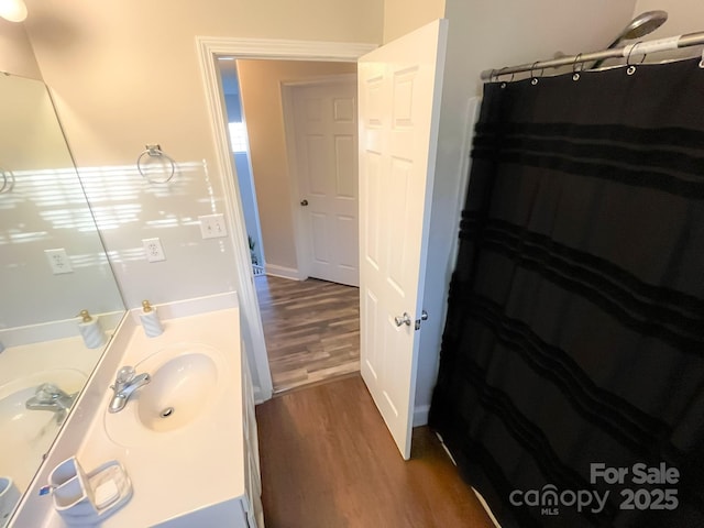 bathroom with wood-type flooring, vanity, and walk in shower