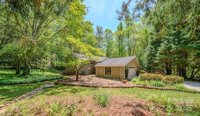 view of front of property featuring an attached garage and a front lawn