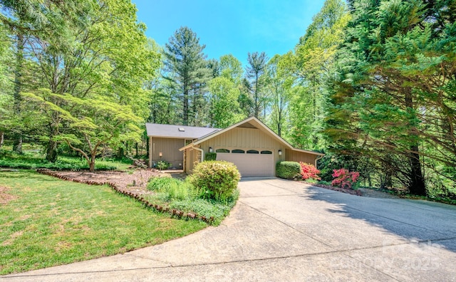 view of front of house featuring an attached garage, driveway, and a front lawn