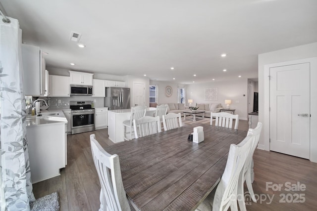 dining area with sink and dark hardwood / wood-style flooring