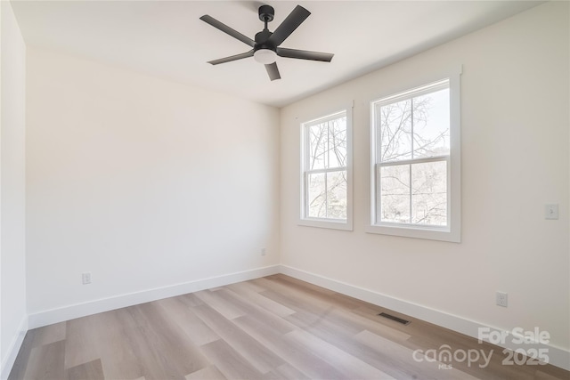 unfurnished room with a ceiling fan, light wood-type flooring, visible vents, and baseboards