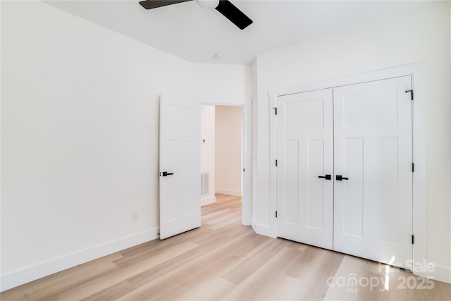 unfurnished bedroom with ceiling fan, light wood-style flooring, visible vents, baseboards, and a closet