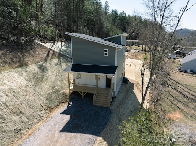 details with dirt driveway and a downspout