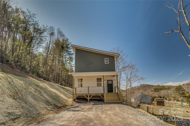 view of front of home featuring covered porch and fence