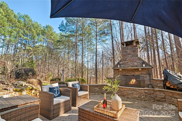 view of patio / terrace with an outdoor living space with a fireplace